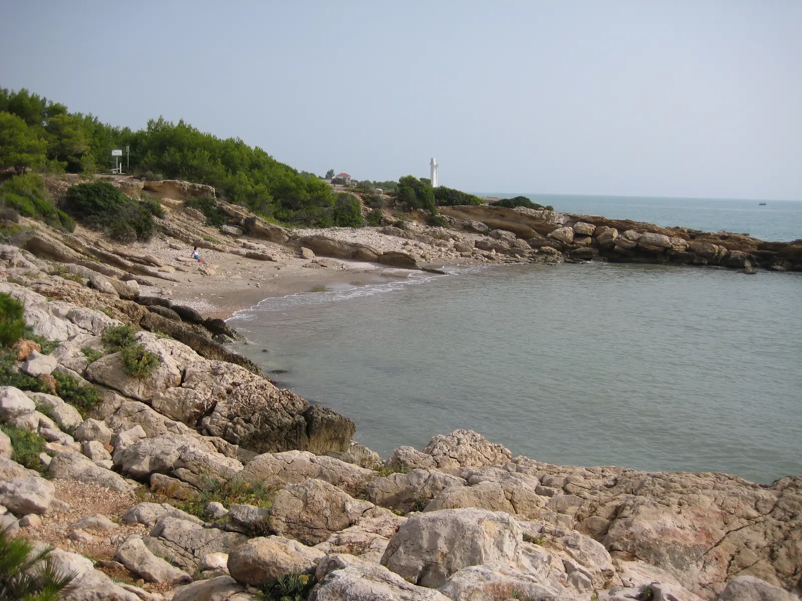 Cala Blanca in Alcossebre mit dem Leuchtturm im Hintergrund, Ausgangspunkt von Wanderungen in der Serra d'Irta