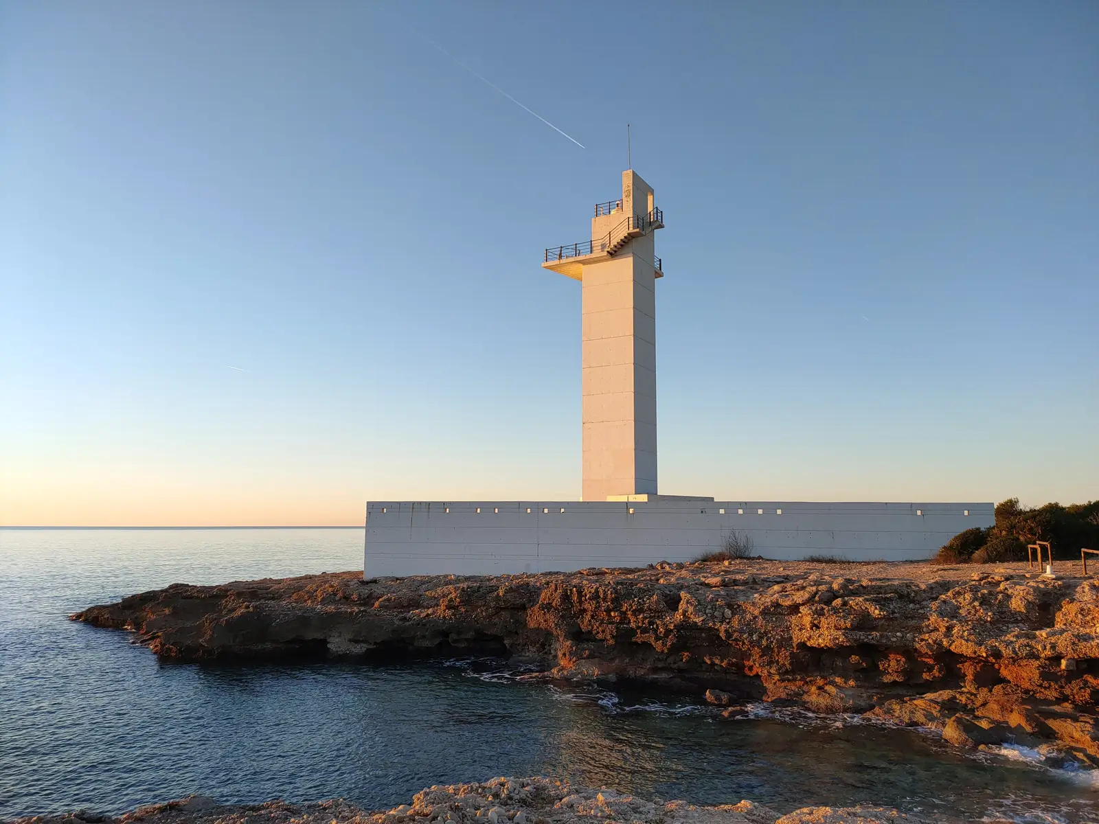 Faro de Alcossebre al amanecer sobre las rocas de la costa, a la entrada de la Sierra de Irta