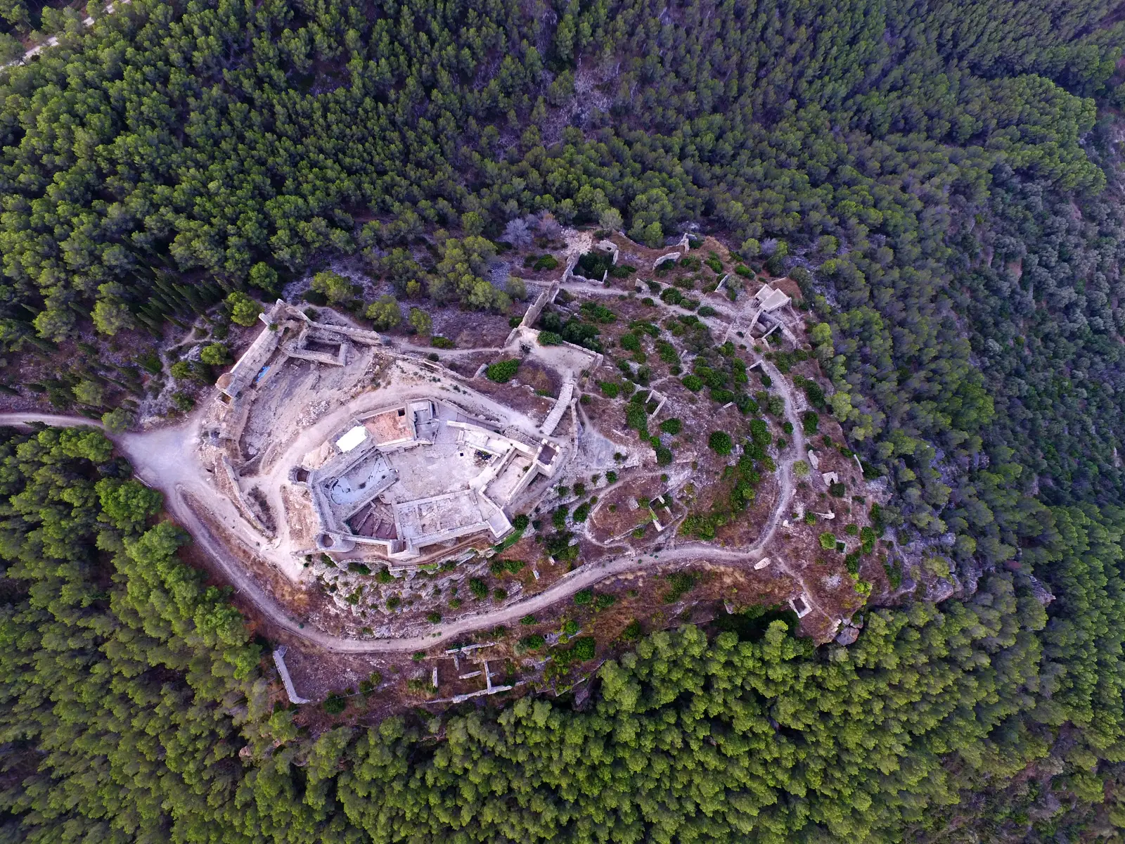 Vista aérea del castillo de Xivert y del poblado morisco amurallado, rodeados de pinar
